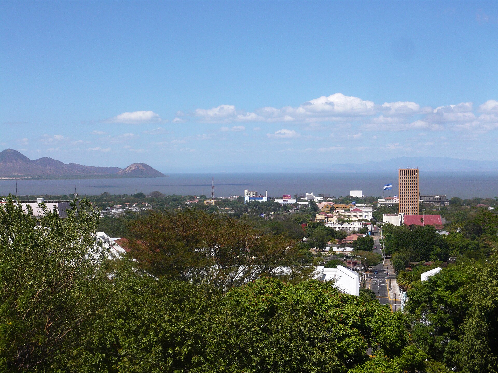 View over Managua from the Loma de Tiscapa hill, with Lake Managua and a national flag above the city centre.