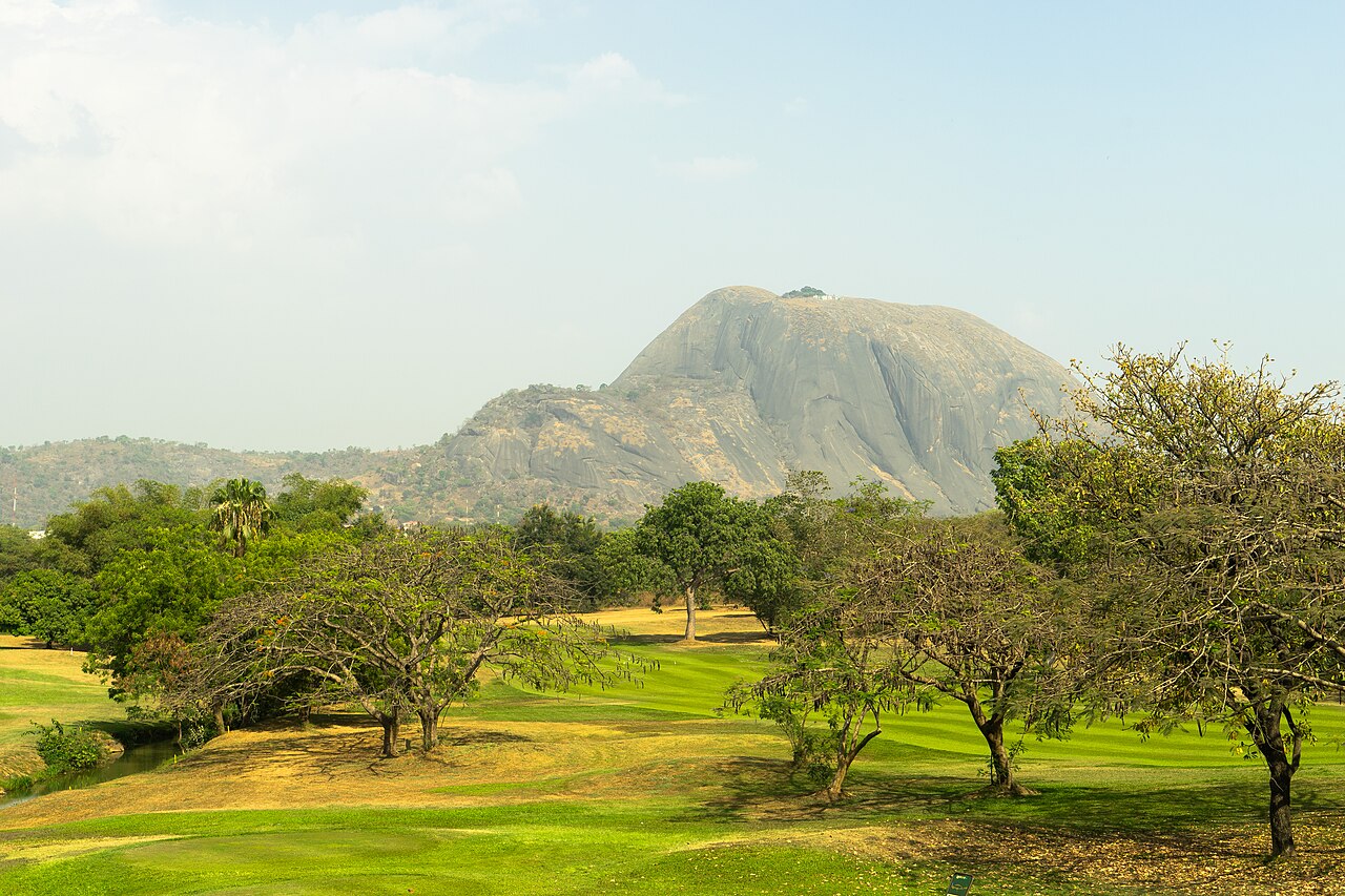 Aso Rock, a granite hill, rising over green trees in Abuja, Nigeria