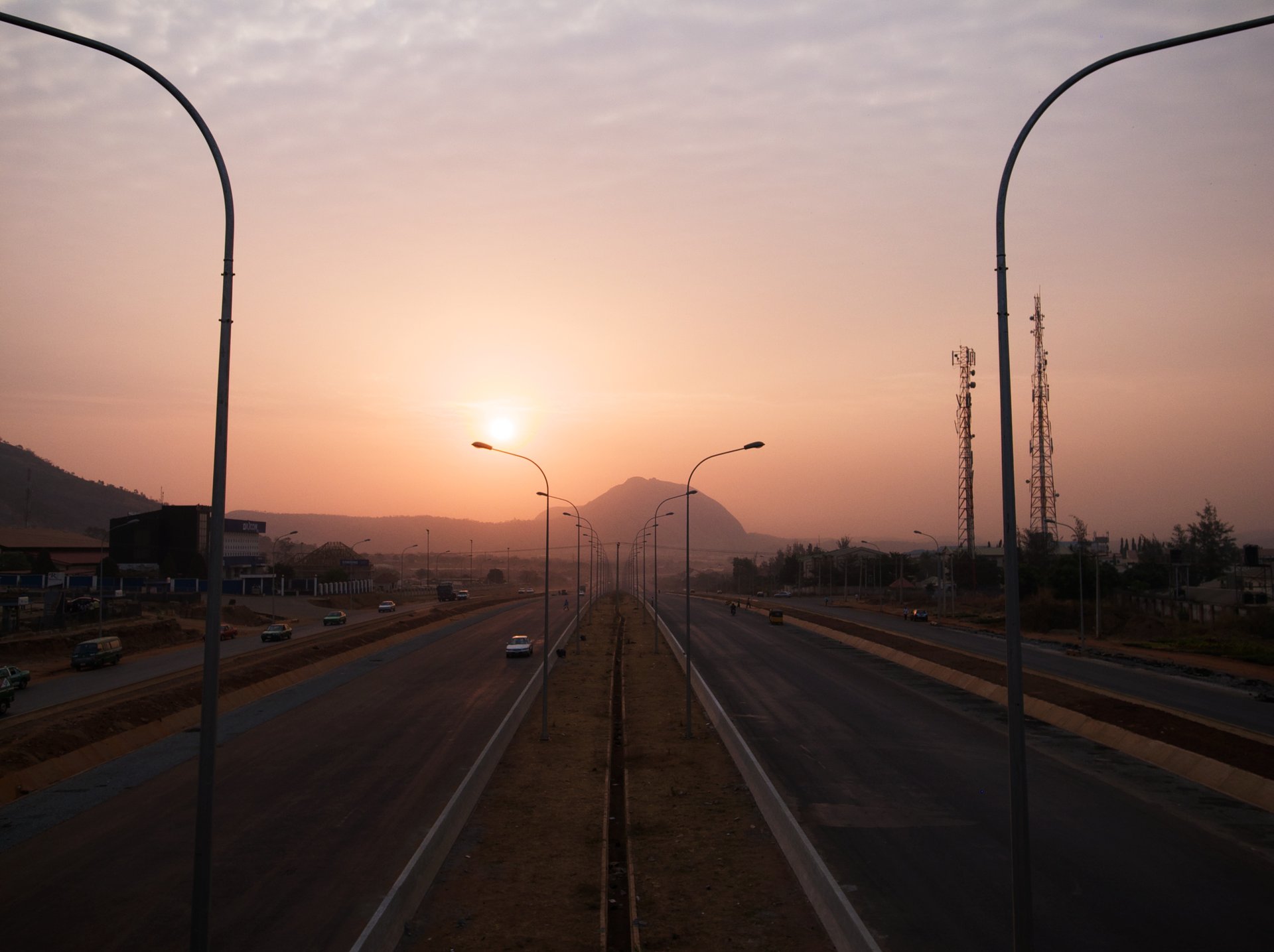 A highway in Abuja at dusk with Aso Rock on the horizon, Nigeria