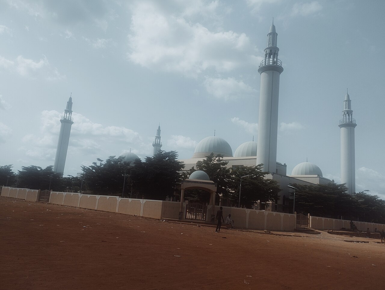 The white domes and minarets of the central mosque in Gombe city, north-eastern Nigeria, behind a perimeter wall