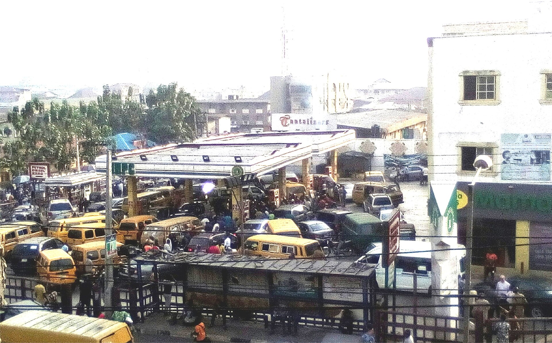 Danfo buses and cars queue at the NNPC filling station in Palm Grove, Lagos