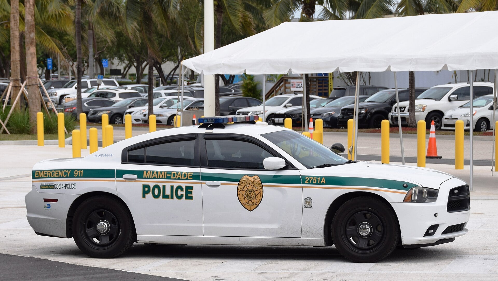 A Miami-Dade police patrol car parked beside a white tent in Miami, Florida