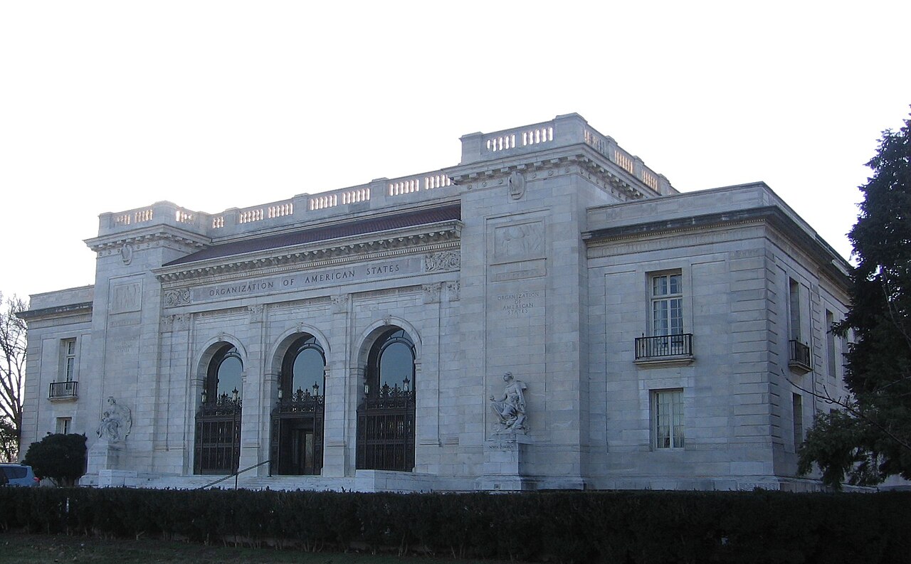 White marble facade with three arched iron gates of the Organization of American States building in Washington