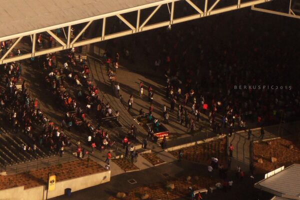 Aerial view of crowds queueing at the open-air amphitheatre of Parque Viva in La Guácima, Costa Rica, under a white steel roof truss.