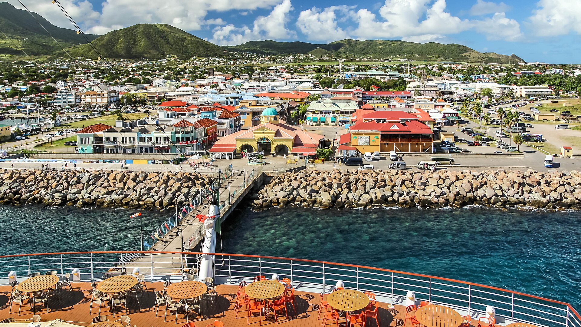 View from a cruise ship deck over the Port Zante pier and the colourful buildings of Basseterre with green hills behind