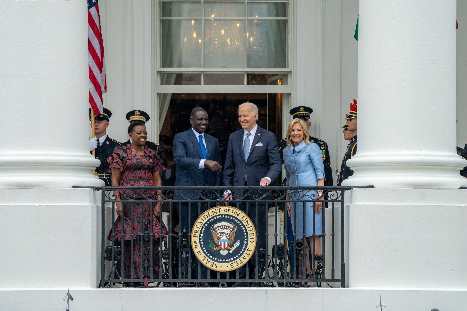Rachel Ruto, William Ruto, Joe Biden and Jill Biden stand on a White House balcony behind the US presidential seal, with honour guards and a US flag