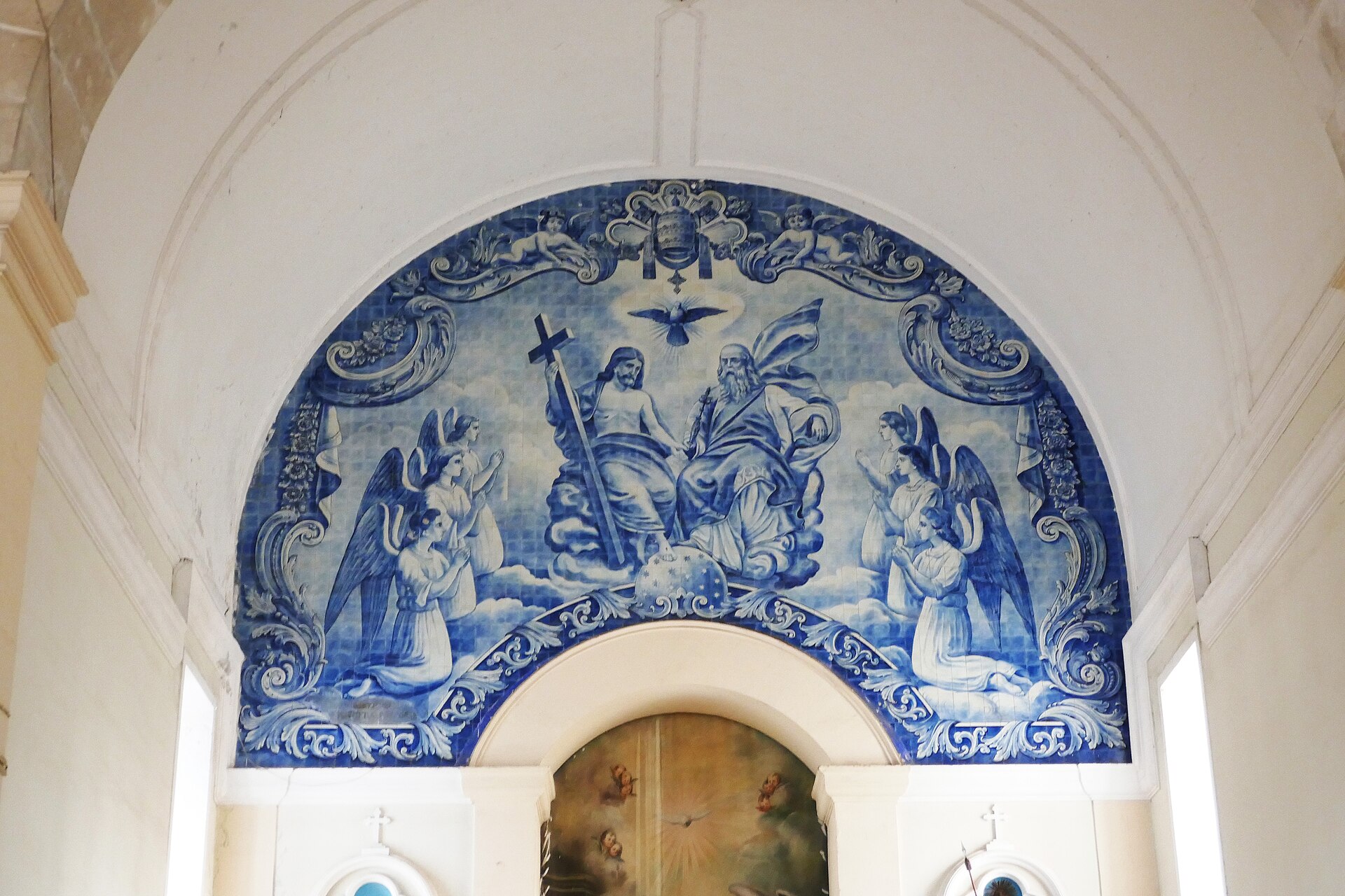 Blue-and-white azulejo tile panel of the Holy Trinity with angels above the nave of the cathedral of São Tomé