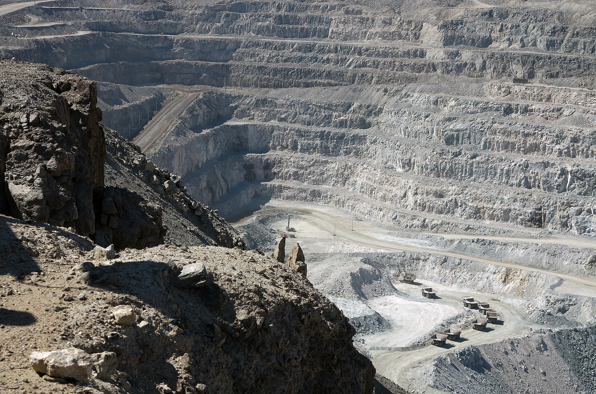 Terraced open pit of the Rossing uranium mine with haul trucks on the pit floor