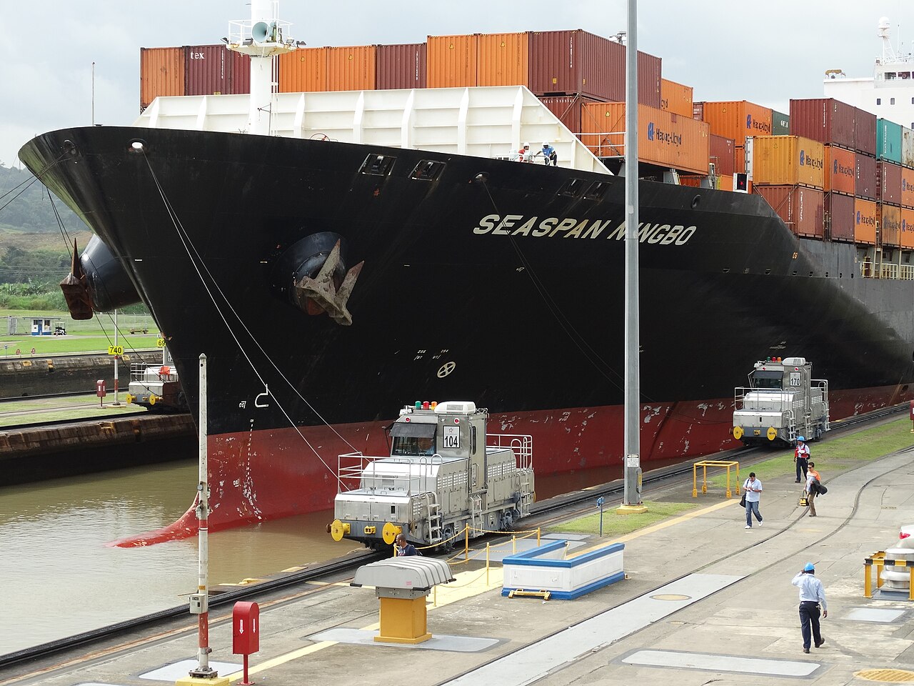 Electric locomotives guide a container ship through the Miraflores Locks of the Panama Canal