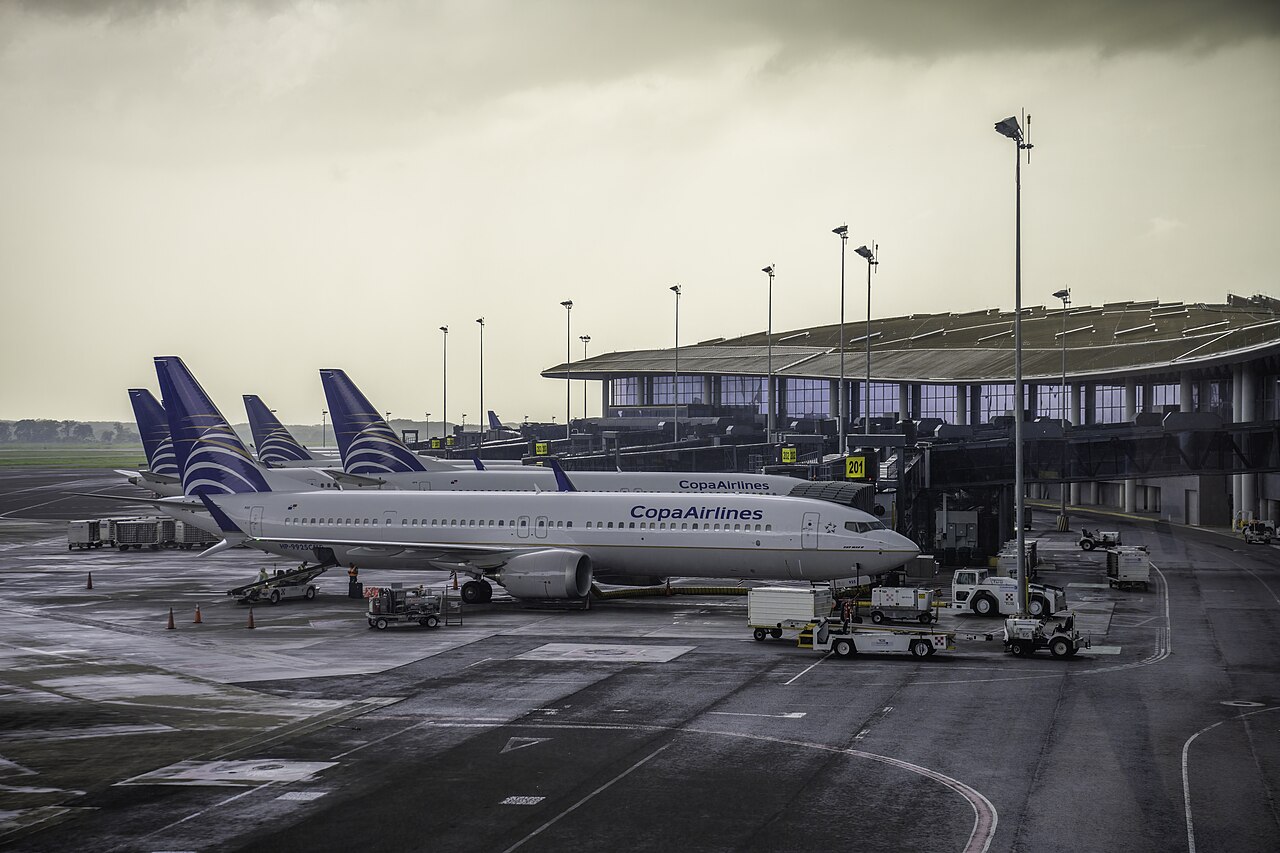 Copa Airlines Boeing 737 jets parked at gates of a terminal at Tocumen International Airport under a grey sky.