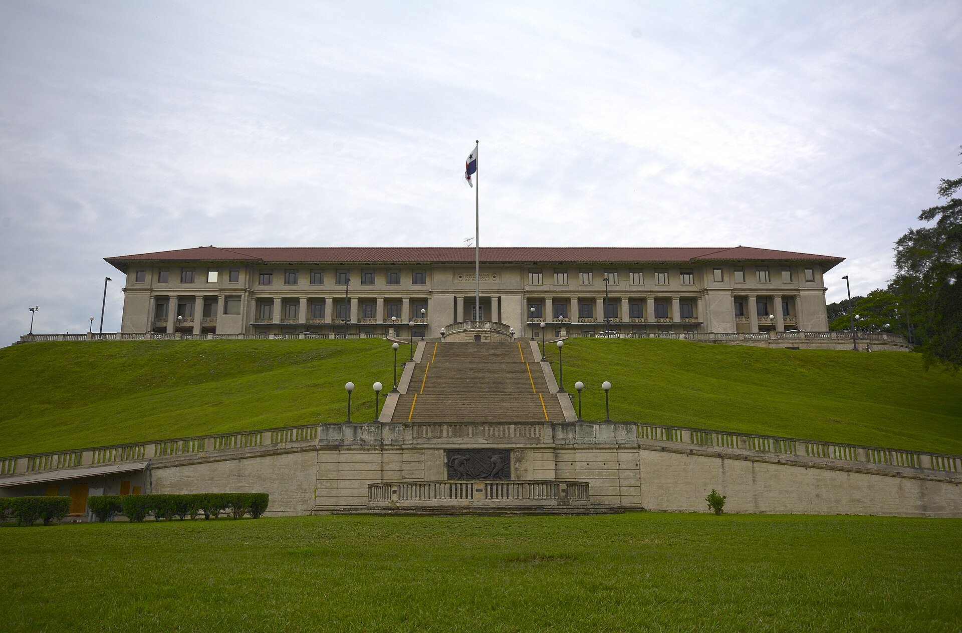 The Administration Building of the Panama Canal at Balboa, a long tiled-roof building at the top of a wide staircase with a Panama flag