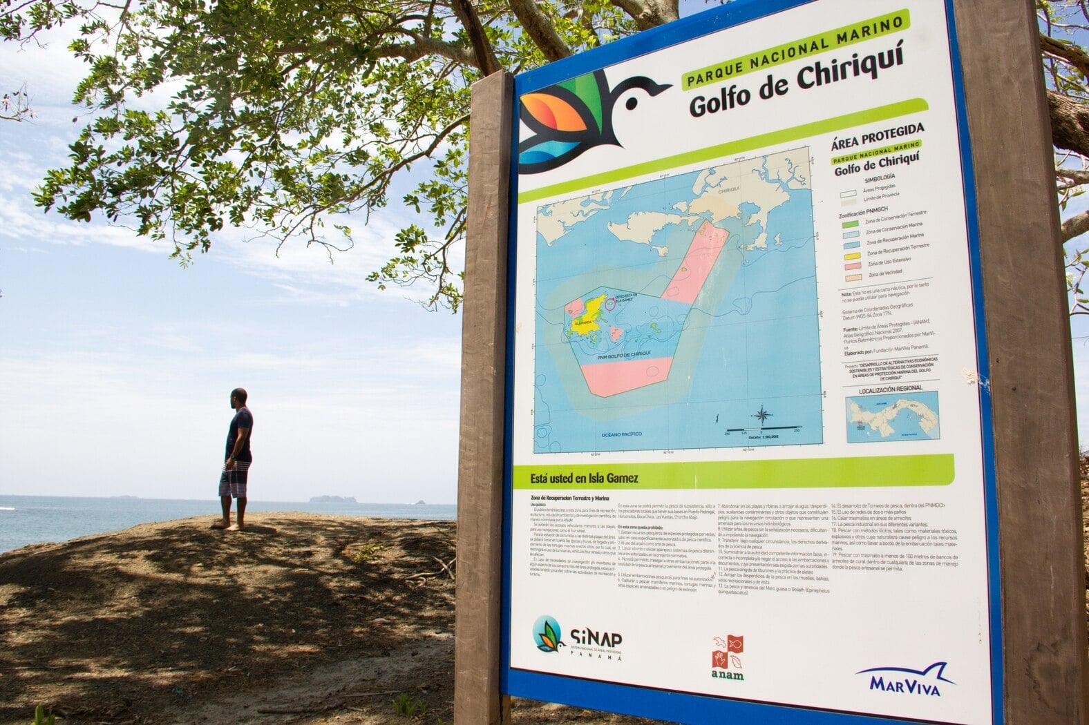 Visitor beside the Gulf of Chiriqu&iacute; National Marine Park information sign on Isla G&aacute;mez, Panama