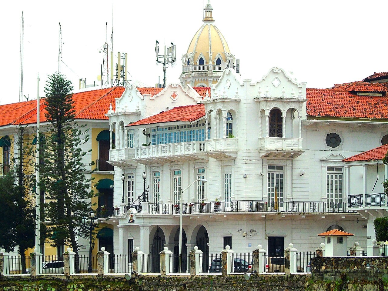 The white Presidential Palace in Panama City with a golden dome, red tile roofs, balconies and an arched ground floor