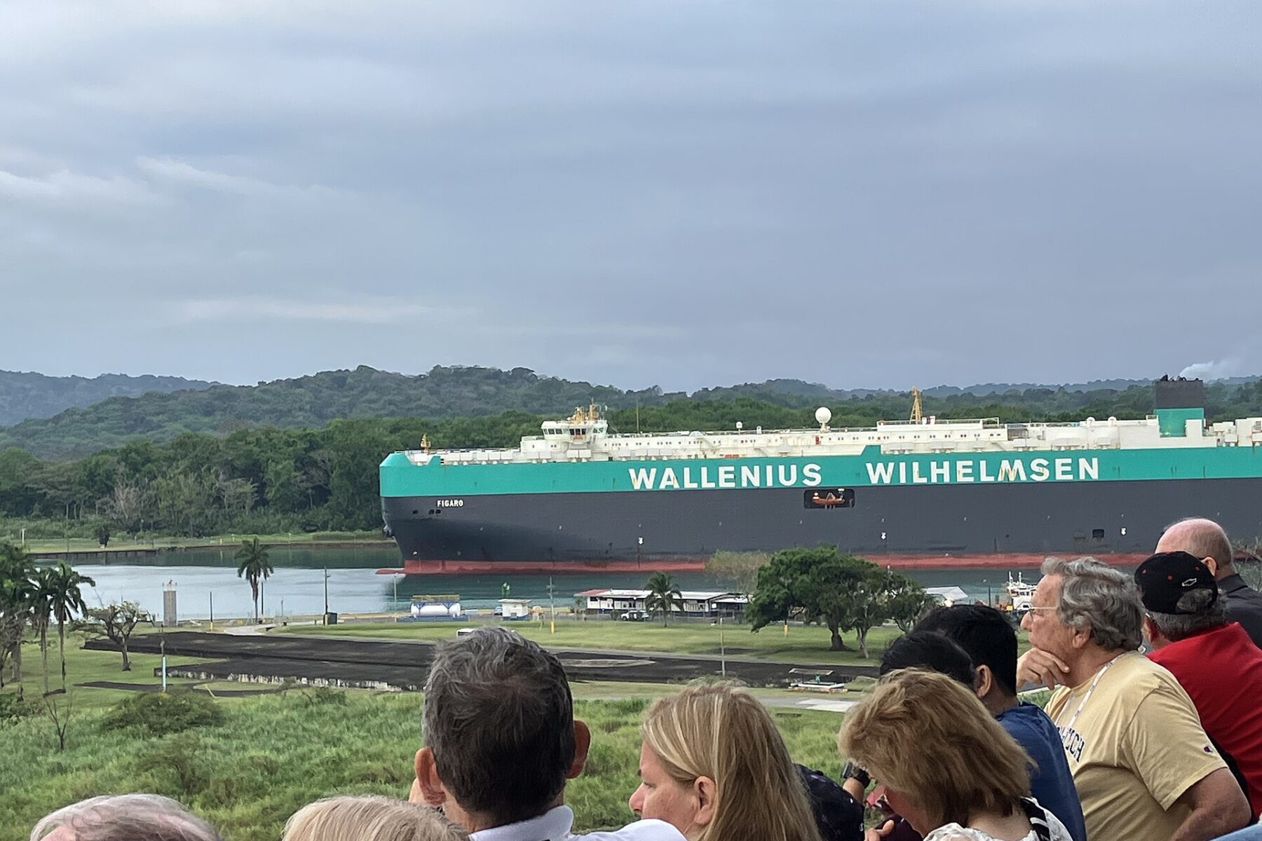 A Wallenius Wilhelmsen car carrier passes a viewing area on the Panama Canal while visitors watch