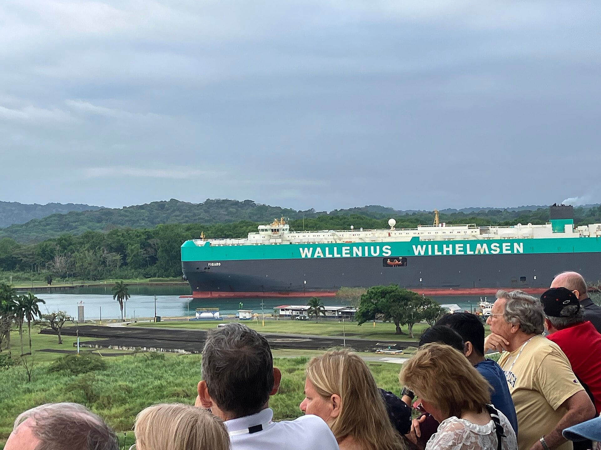 A Wallenius Wilhelmsen car carrier passes a viewing area on the Panama Canal while visitors watch