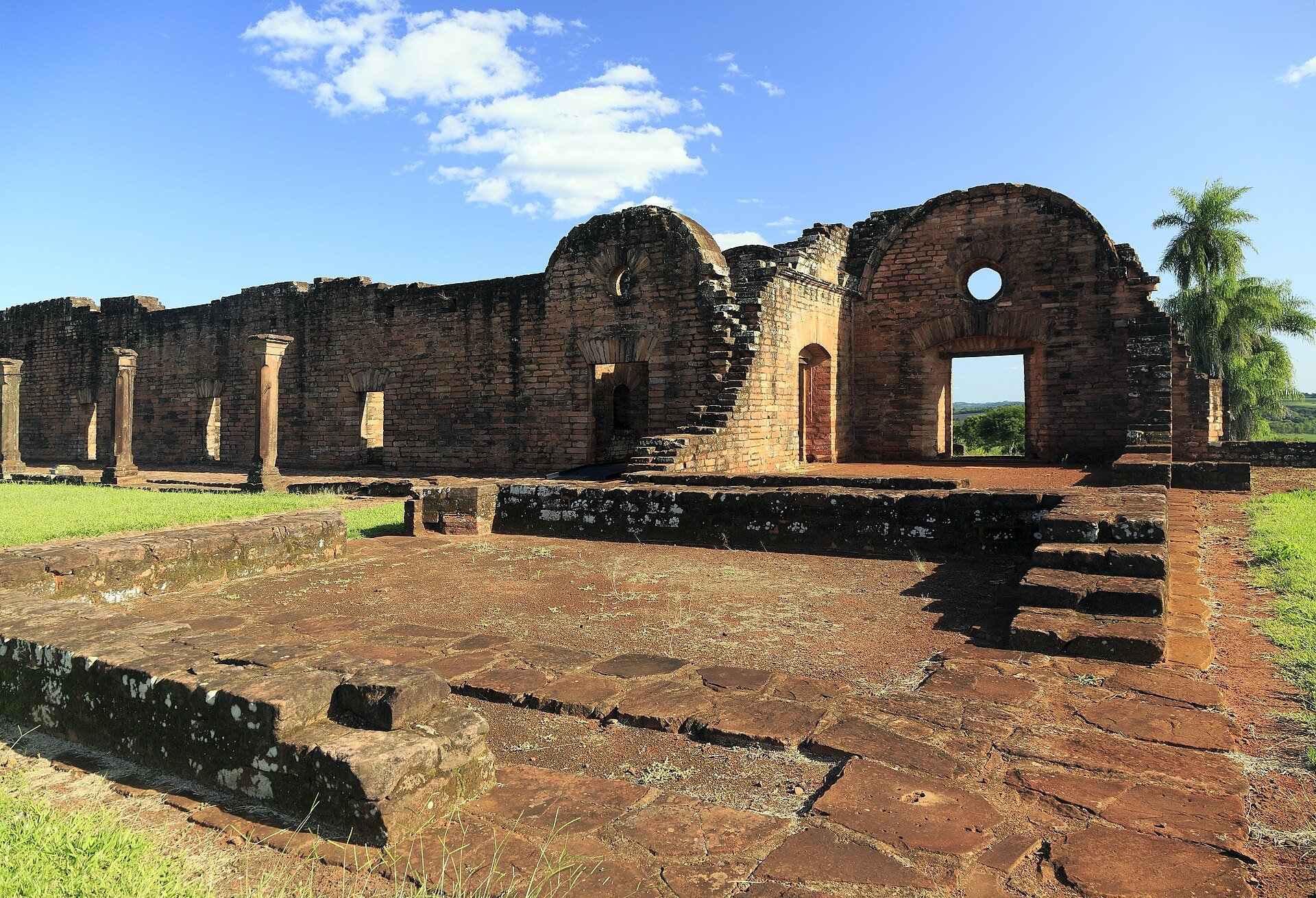 Brick and sandstone ruins of the Jesuit mission of Jesús de Tavarangué in Paraguay under a blue sky