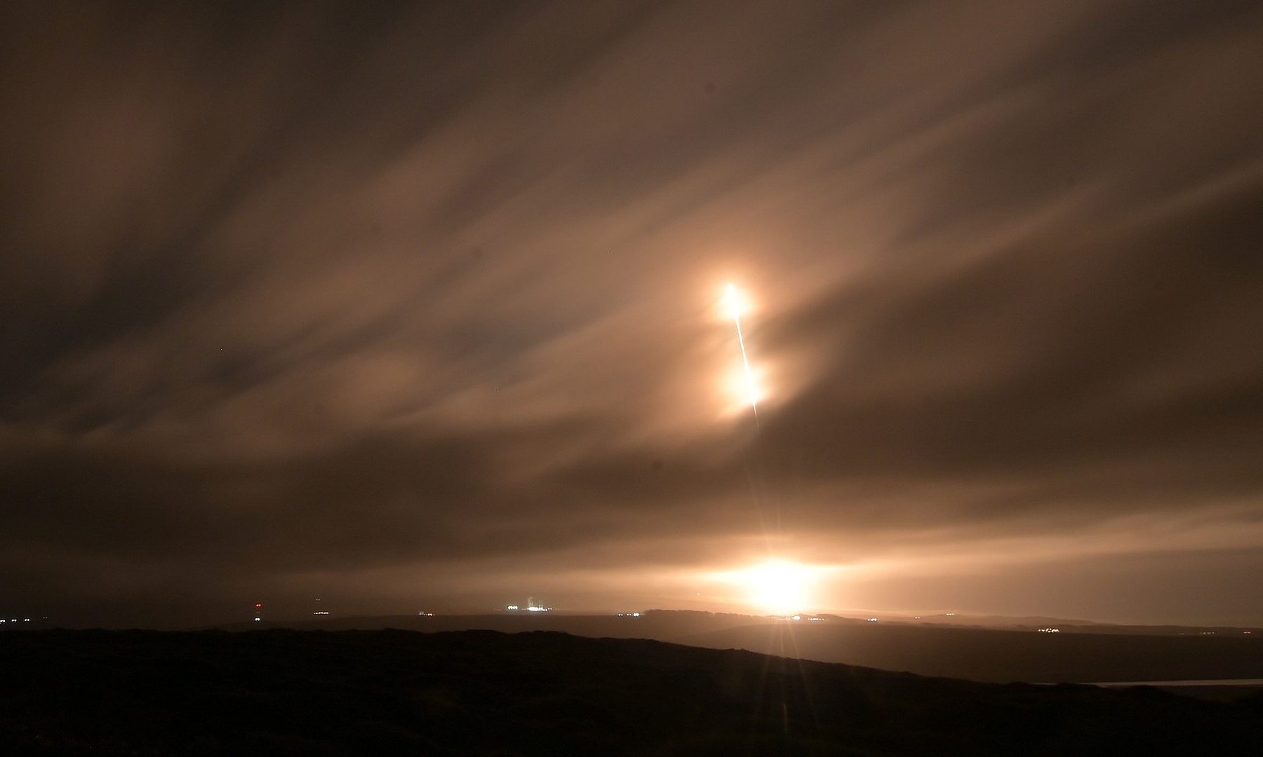 Paraguay GuaraníSat-2 satellite: long-exposure photo of a SpaceX Falcon 9 rideshare rocket climbing through clouds at night from Vandenberg, California
