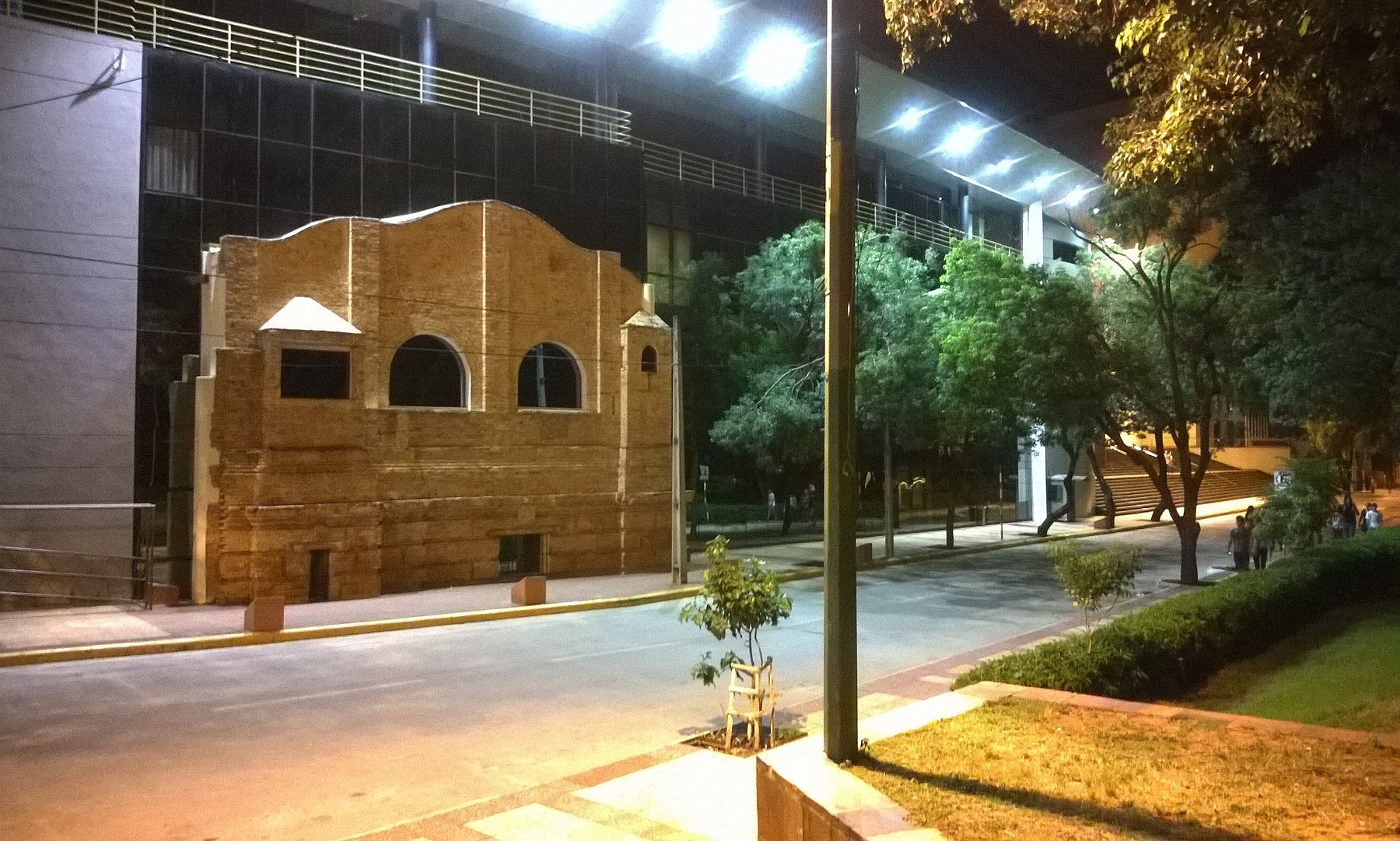The National Congress building in Asunción, Paraguay, at night, with an old brick facade in front of the modern glass chamber