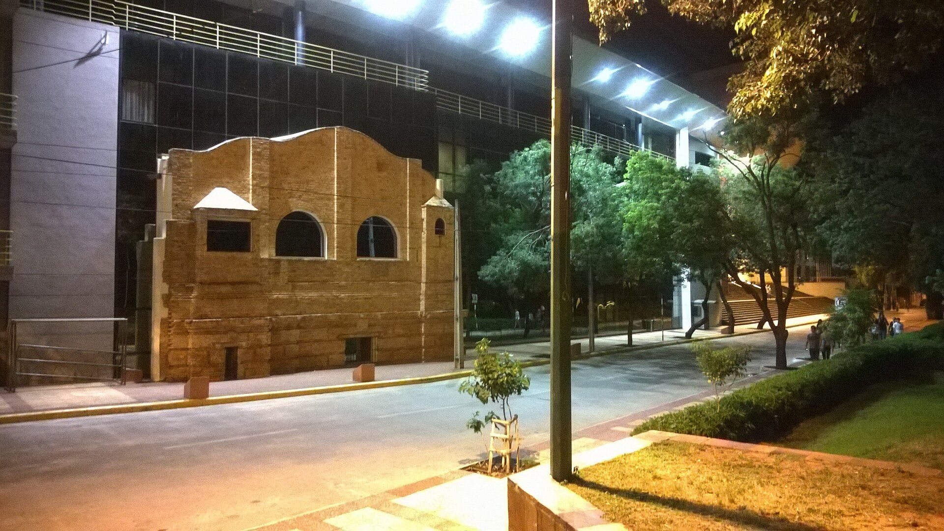 The National Congress building in Asunción, Paraguay, at night, with an old brick facade in front of the modern glass chamber