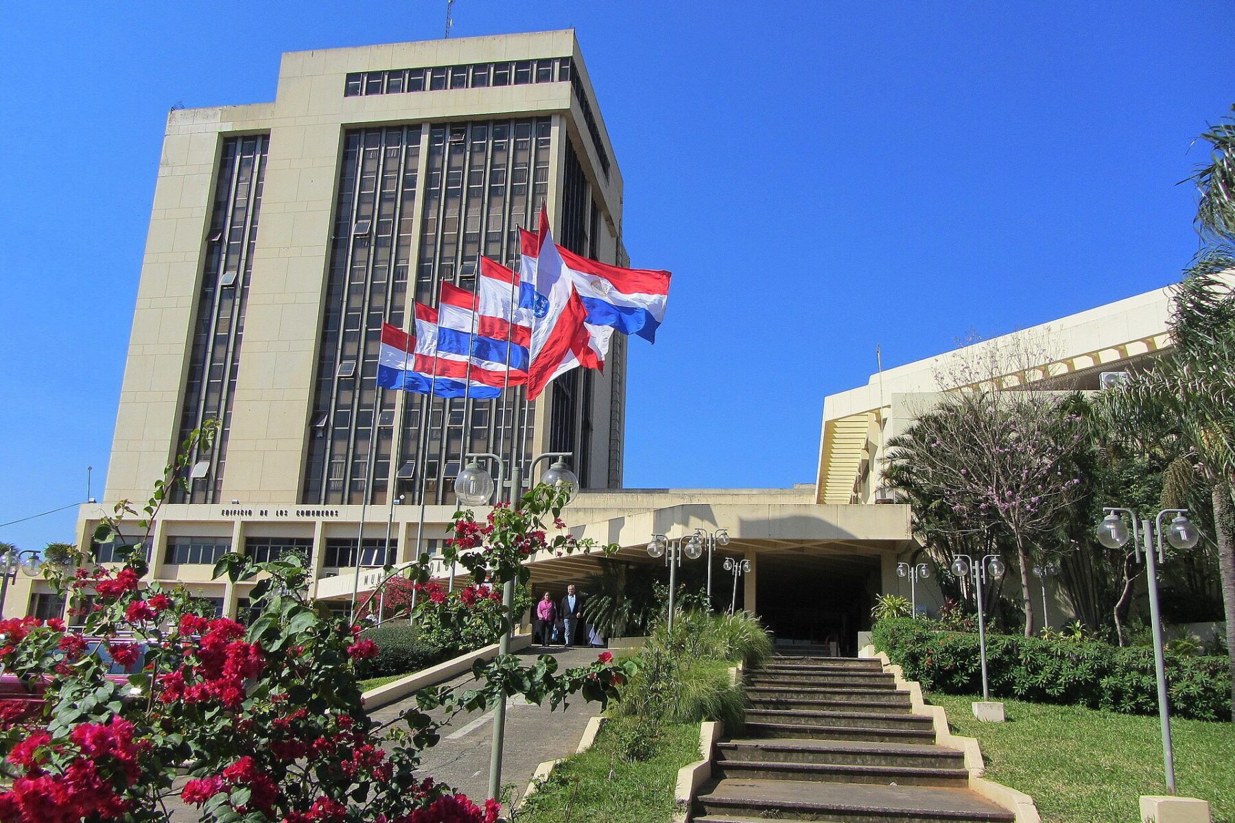 Asunción city hall tower with Paraguayan and city flags under a blue sky