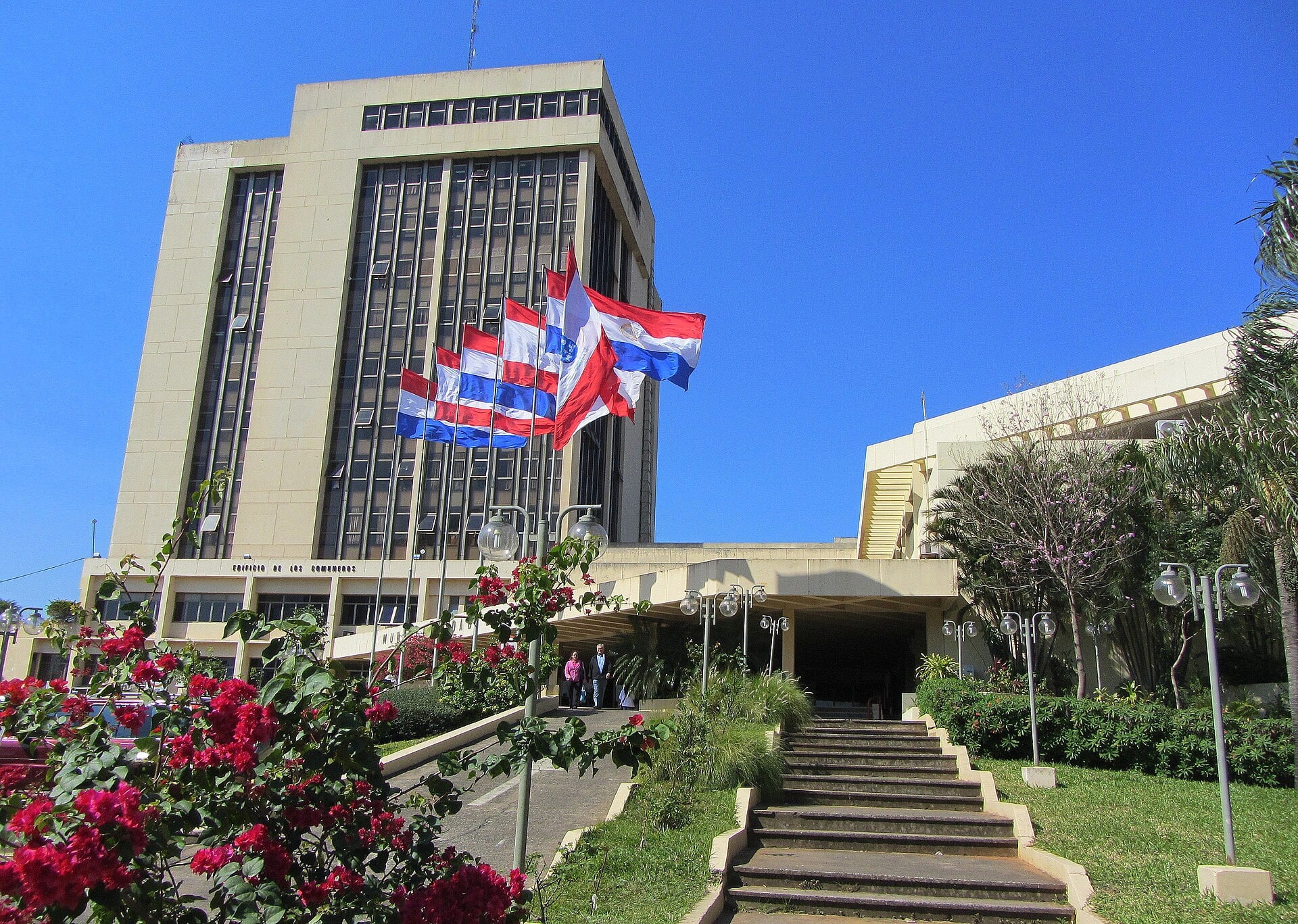 Asunción city hall tower with Paraguayan and city flags under a blue sky