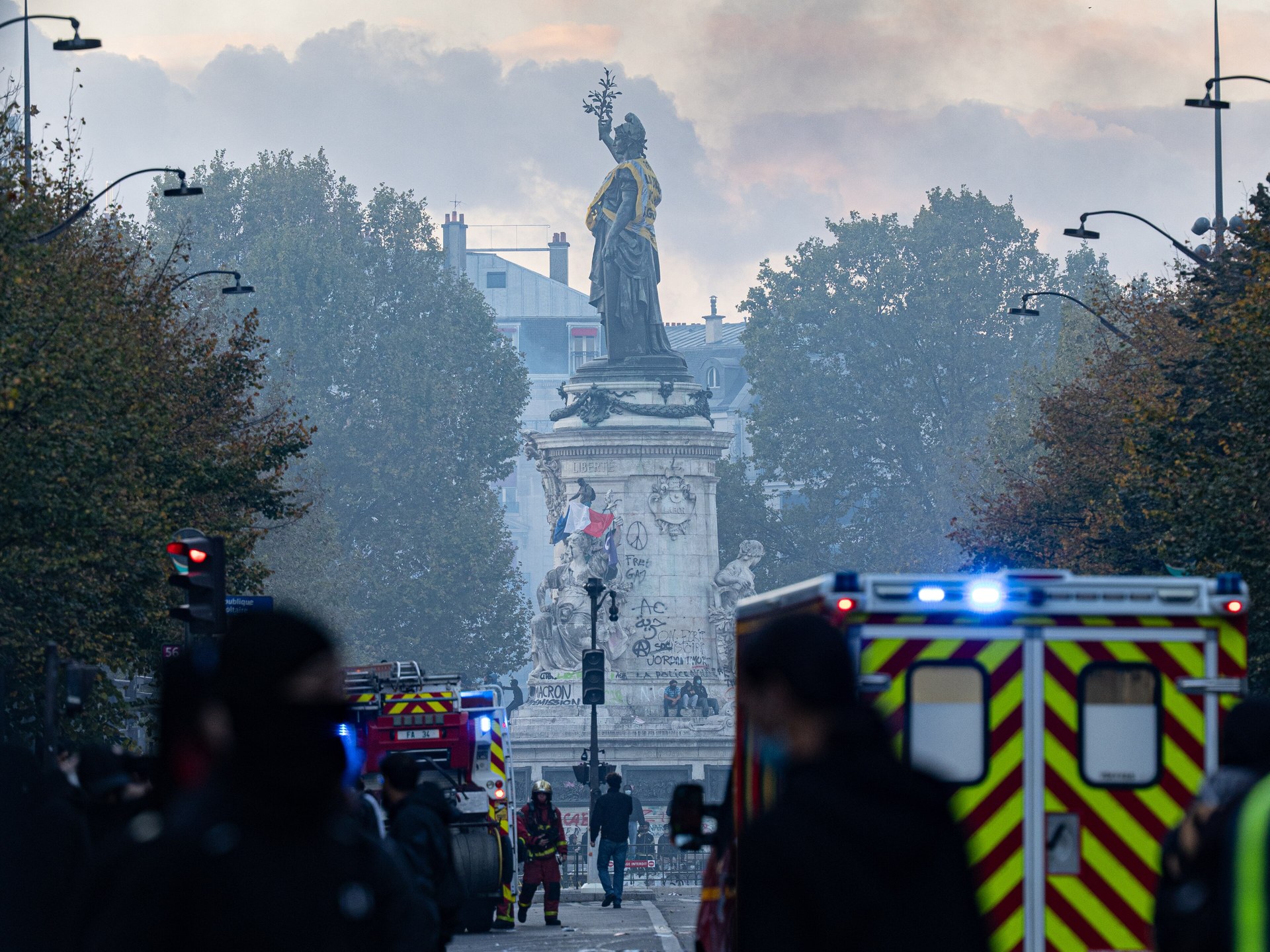 Fire brigade vehicles with flashing lights near the Place de la République statue in Paris on 17 October 2026