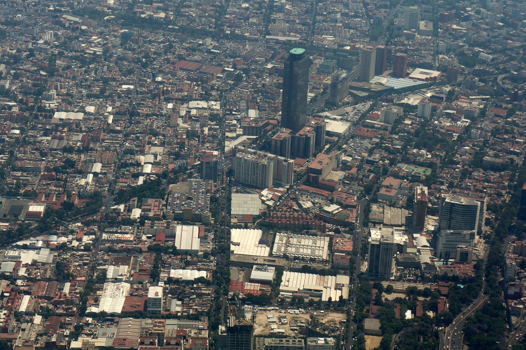 Aerial view of the Pemex Tower rising above dense neighbourhoods of Mexico City