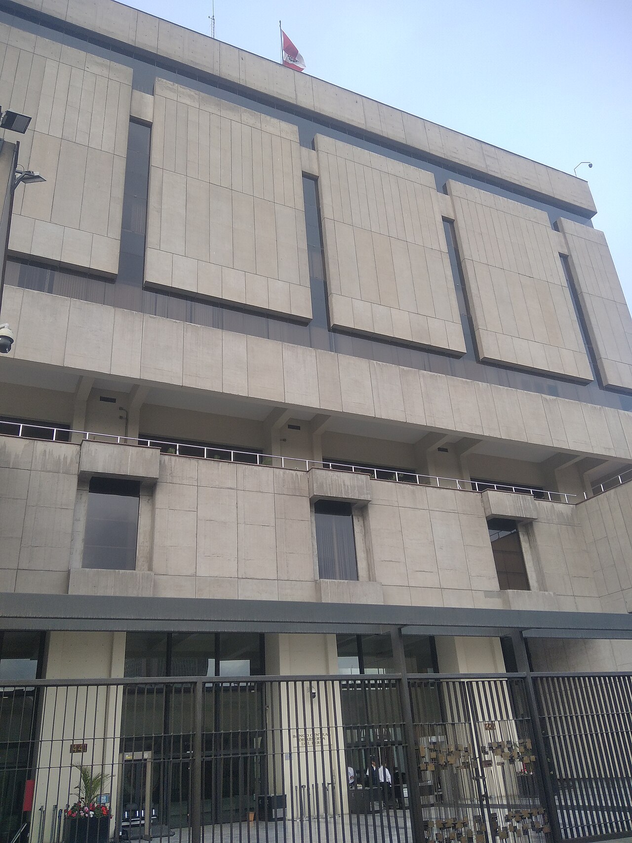 Gated entrance of the Central Reserve Bank of Peru building at number 441 in Lima, with a Peruvian flag on the roof