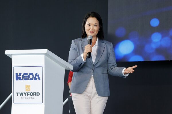Peru's President Keiko Fujimori speaks into a microphone beside a white lectern at a public event