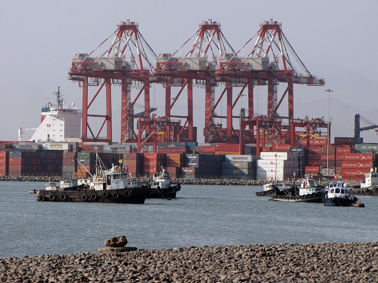 Container cranes, stacked containers and tugboats at the port of Callao, Peru
