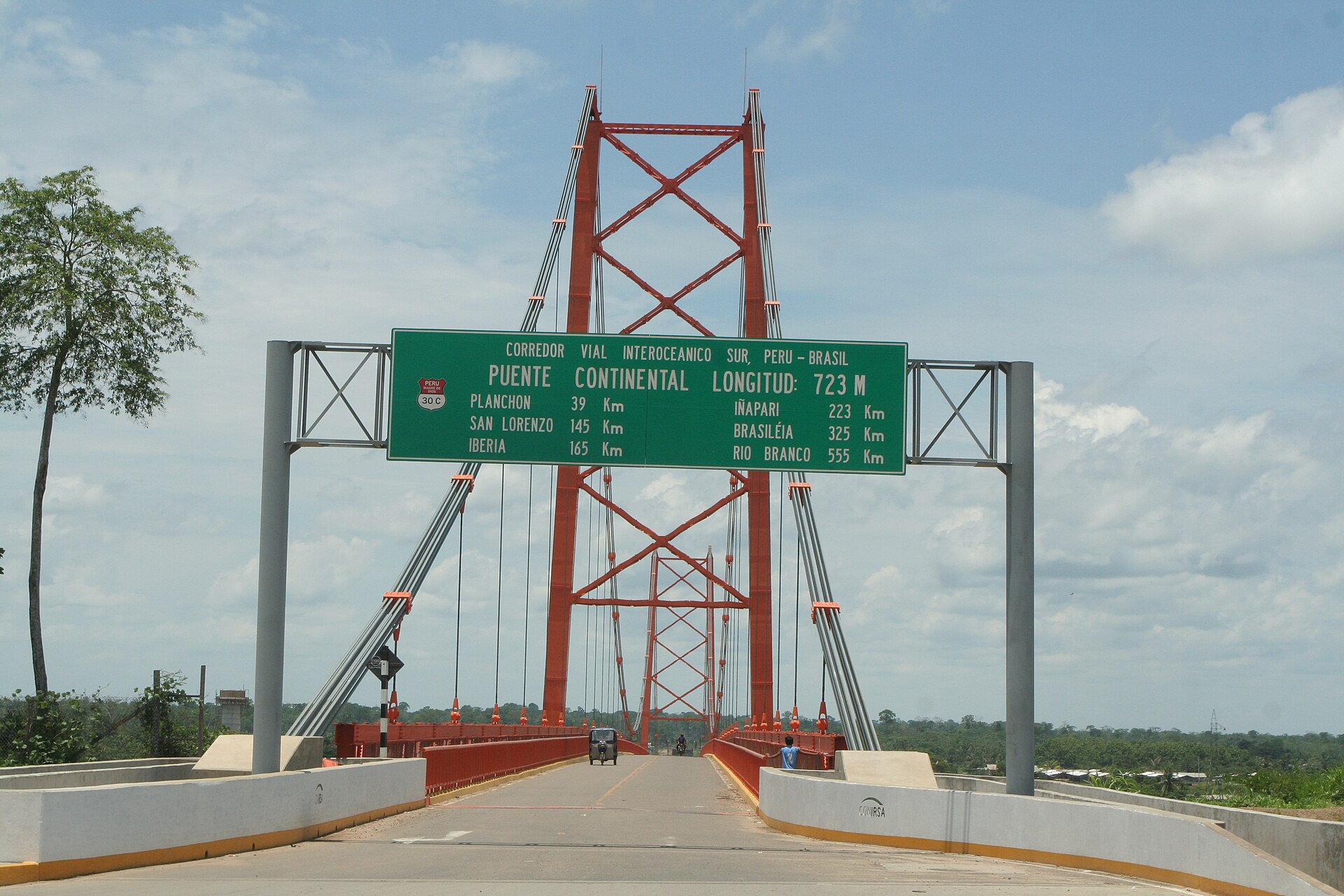 Red suspension bridge carrying the Interoceanic Highway over the Madre de Dios River near Puerto Maldonado