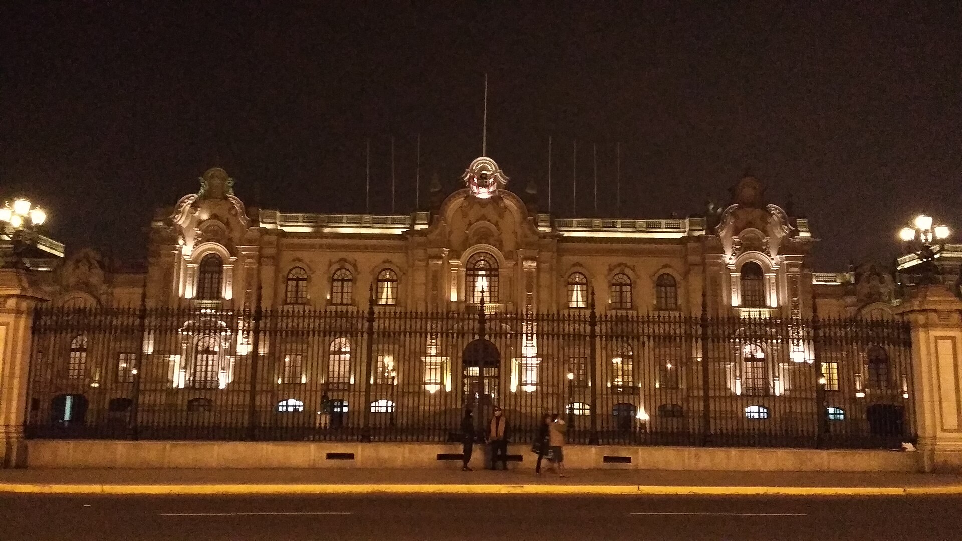 The Government Palace of Peru in Lima lit at night behind its iron fence