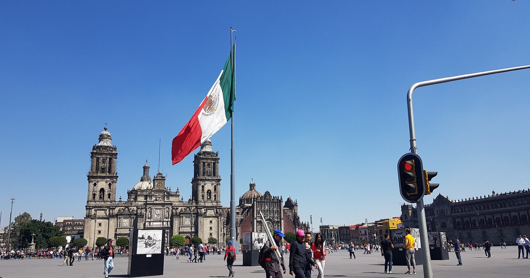 A large Mexican flag flies over the Zócalo in Mexico City with the Metropolitan Cathedral behind
