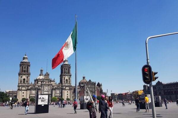 A large Mexican flag flies over the Zócalo in Mexico City with the Metropolitan Cathedral behind