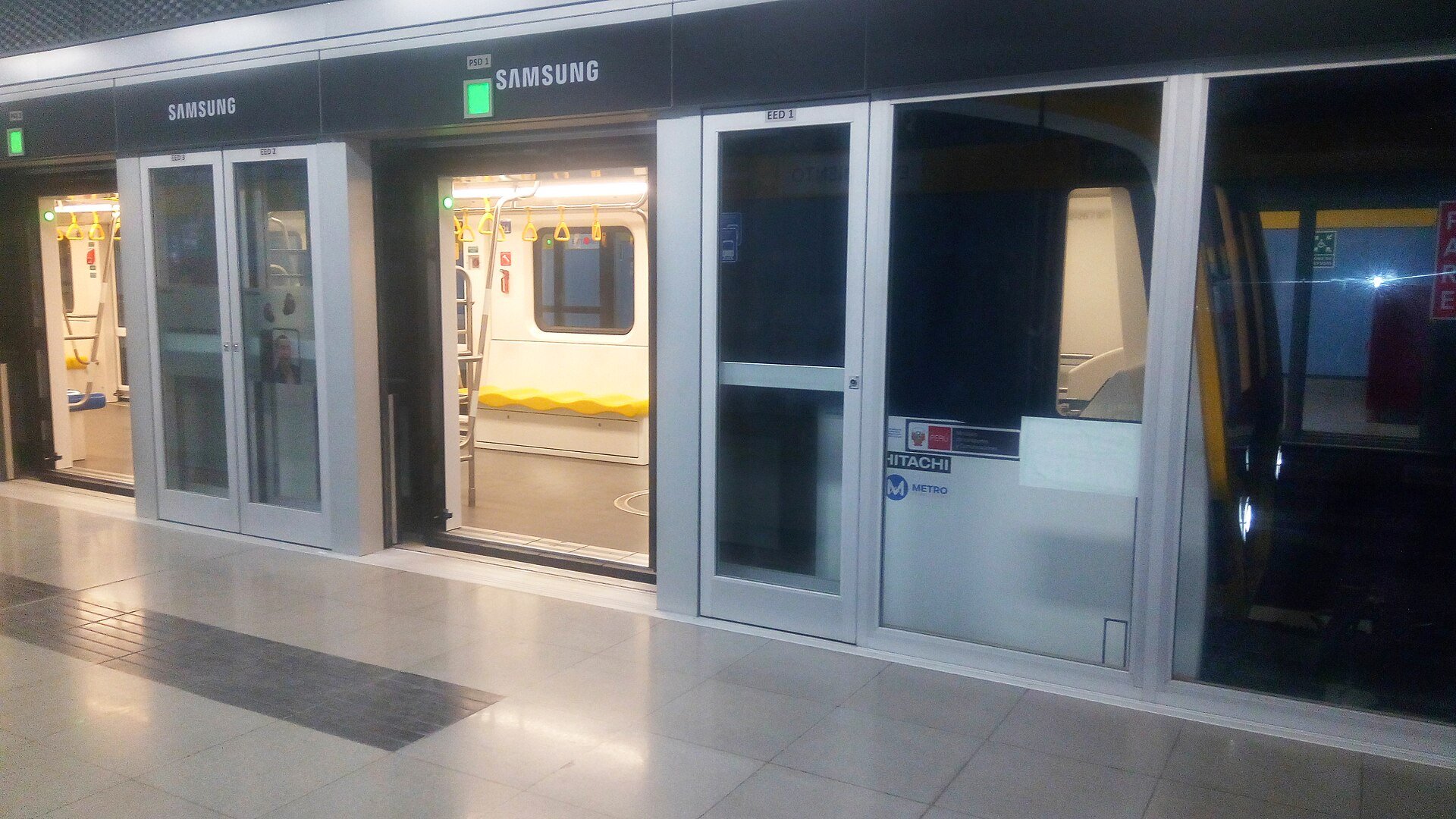 A Hitachi Rail train with its doors open at a platform of Lima Metro Line 2