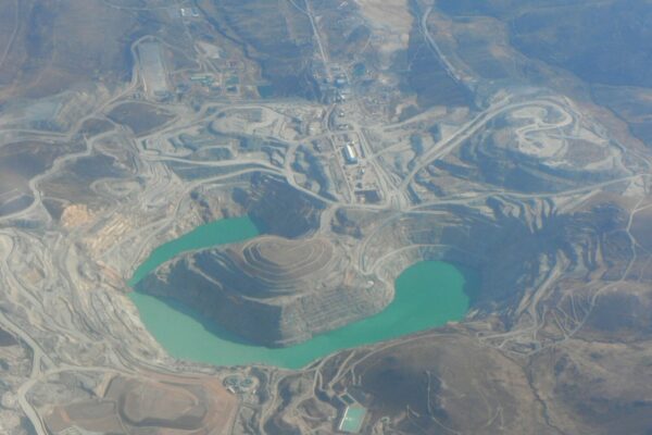 Aerial view of the Tintaya open-pit copper mine in Peru's Cusco region with a turquoise pit lake