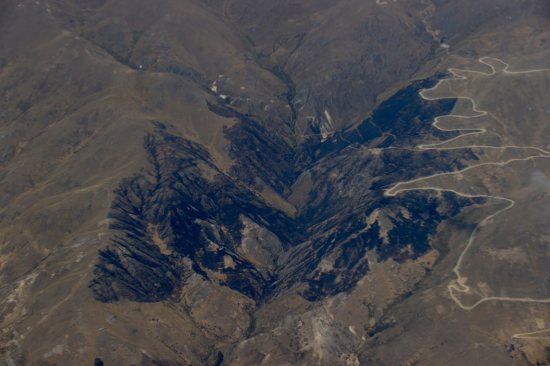 Burned black slopes of an Andean valley in Peru seen from the air, a file photo of a wildfire scar in Áncash in September 2024, for Peru wildfires