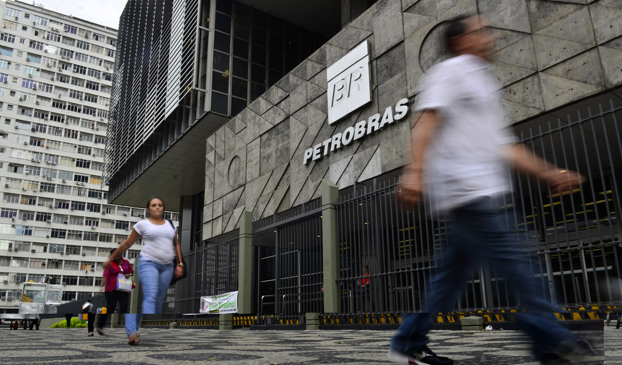 Petrobras logo on the grey stone façade of the company's headquarters in Rio de Janeiro as pedestrians walk past