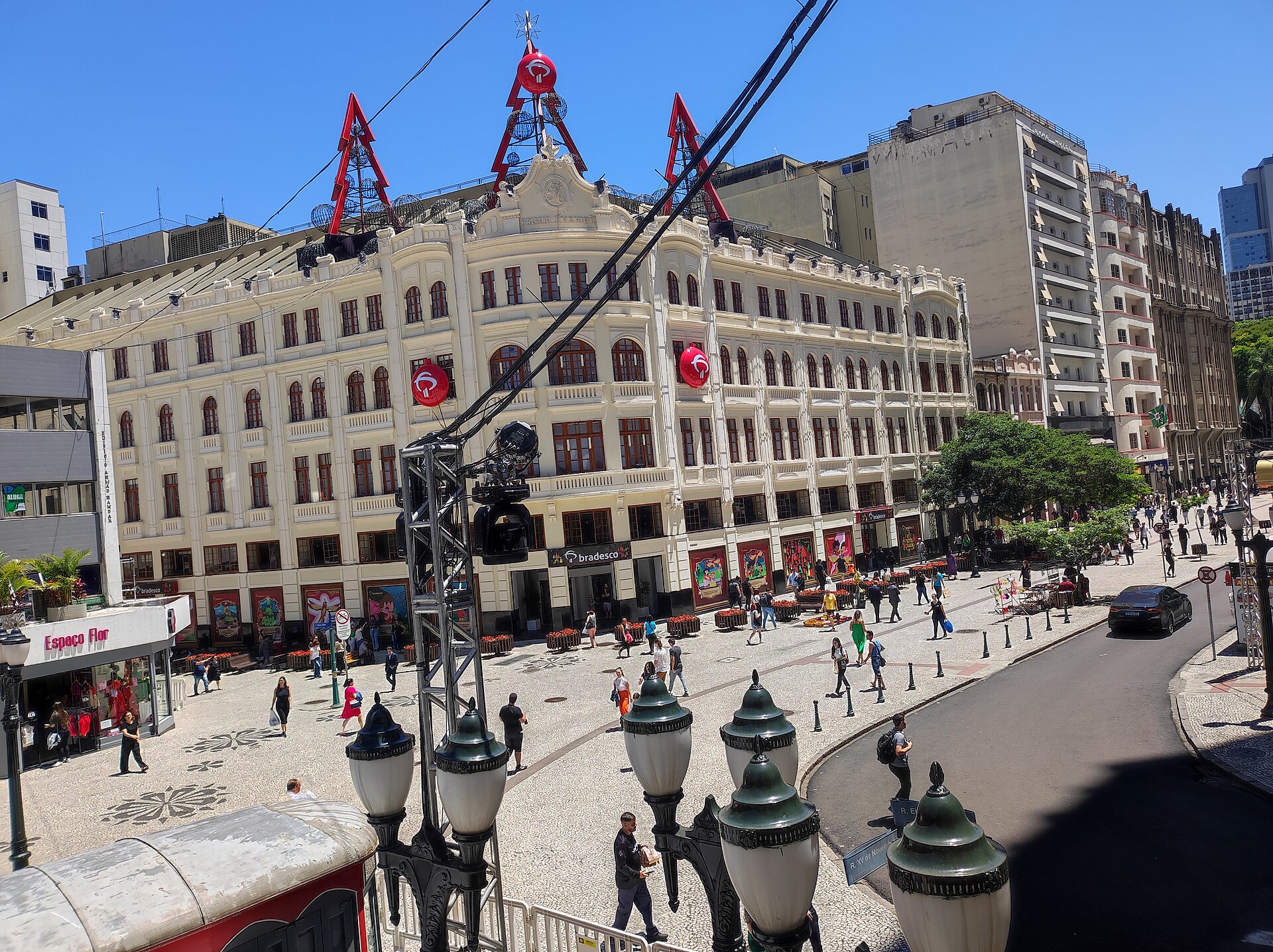 Pedestrians on Rua XV de Novembro in central Curitiba in front of a white historic building and apartment towers