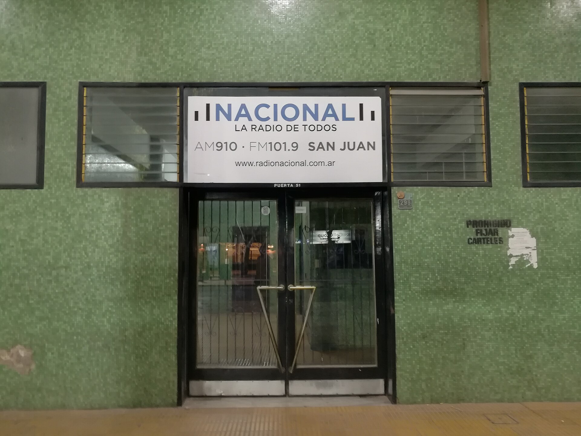 The entrance of the Radio Nacional studios in San Juan with a sign reading Nacional, La Radio de Todos, AM910 FM101.9