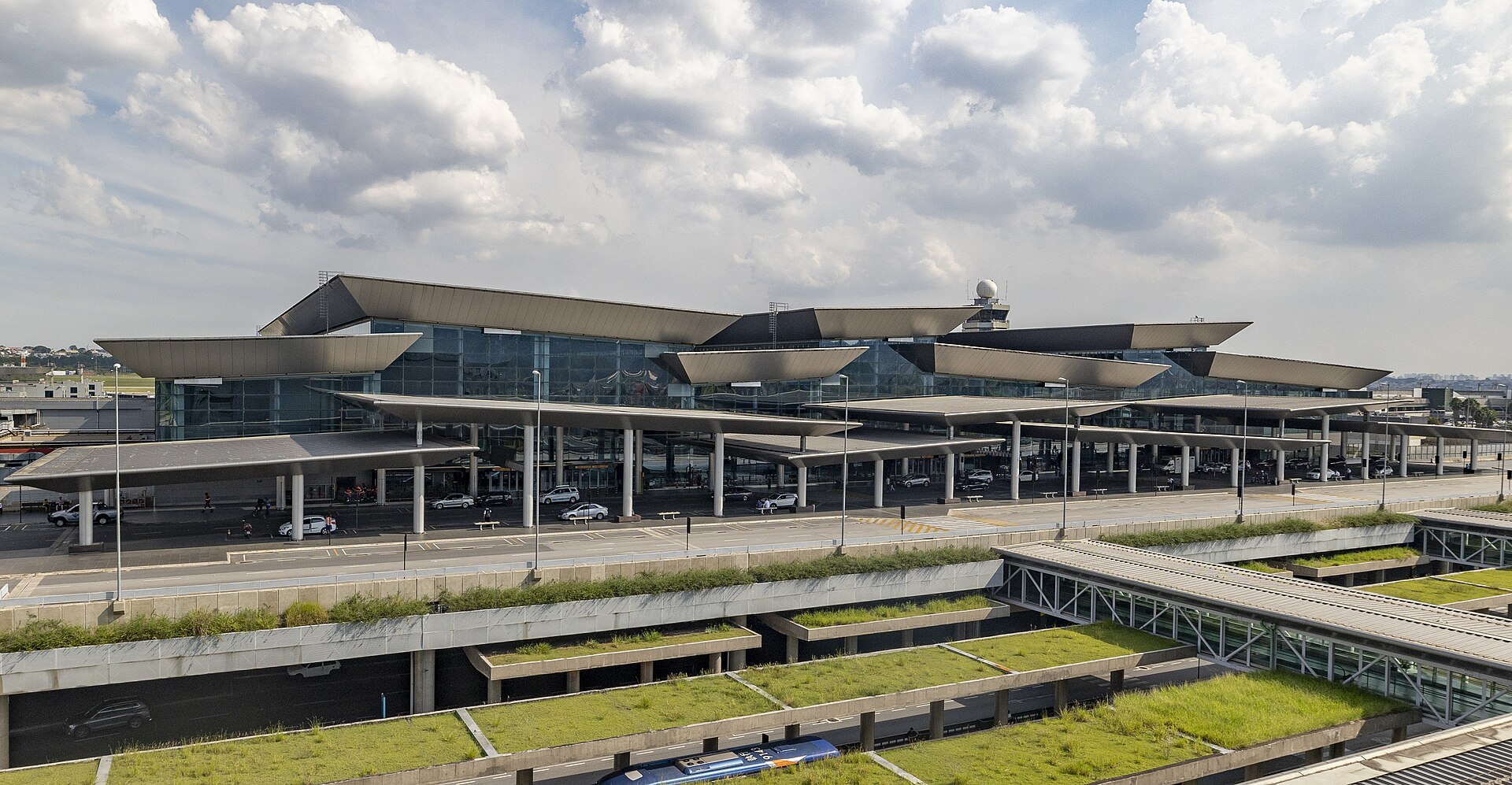 Exterior of Terminal 3 at Sao Paulo Guarulhos International Airport with curved roof canopies, glass facade and green roof gardens