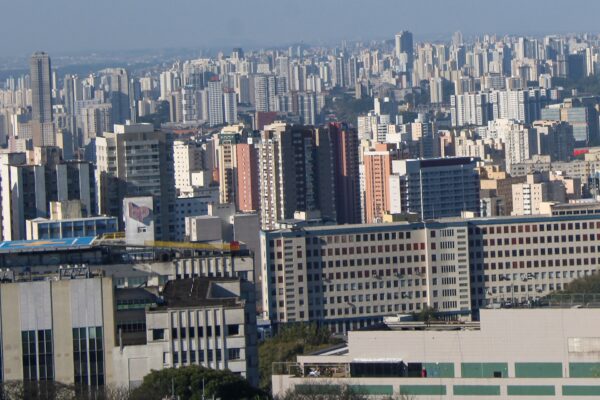 Dense skyline of high-rise apartment and office towers across São Paulo, Brazil, under a hazy sky