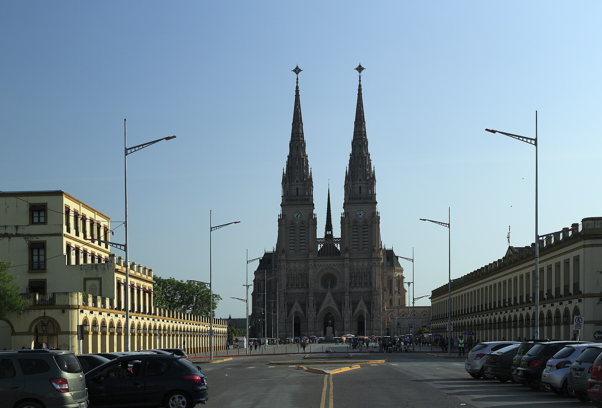 The twin neo-Gothic spires of the Basilica of Lujan at the end of a wide square lined with arcaded buildings