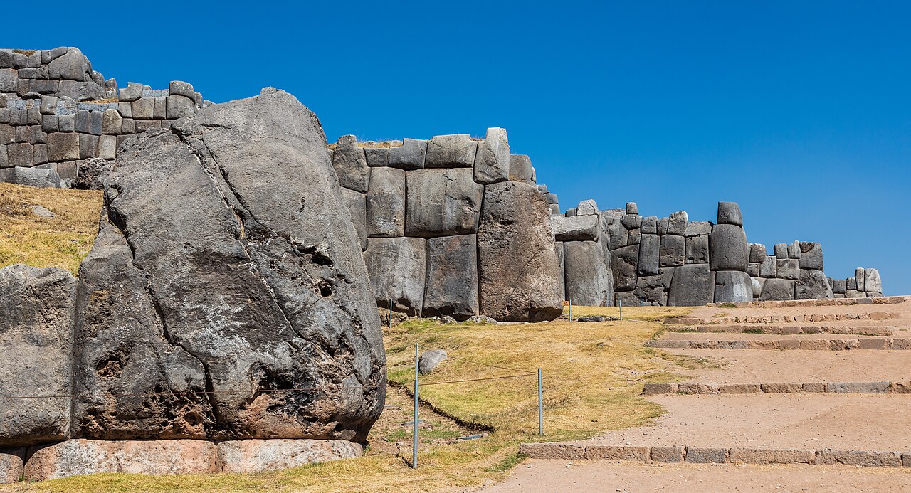 Massive Inca stone walls at the Sacsayhuamán archaeological site above Cusco, Peru, under a blue sky