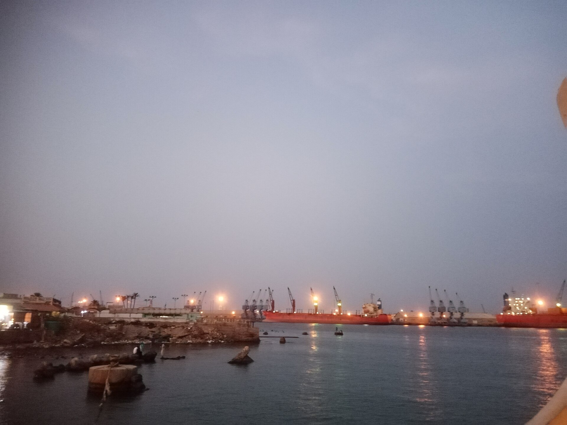 Cargo ships and quayside cranes lit at dusk in the harbour of Port Sudan on the Red Sea