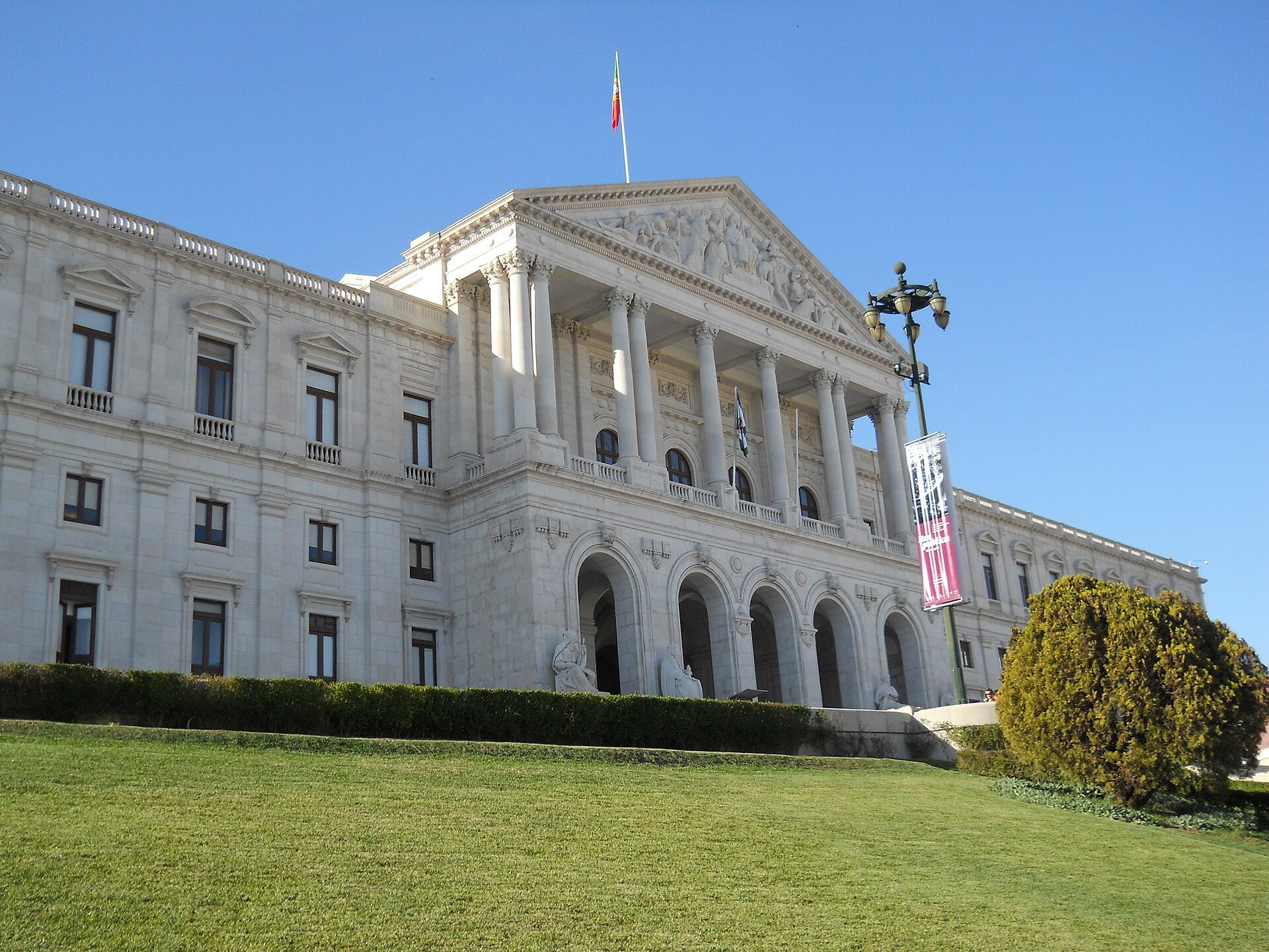 The Palácio de São Bento in Lisbon, seat of the Portuguese Parliament, with a white neoclassical façade and a lawn