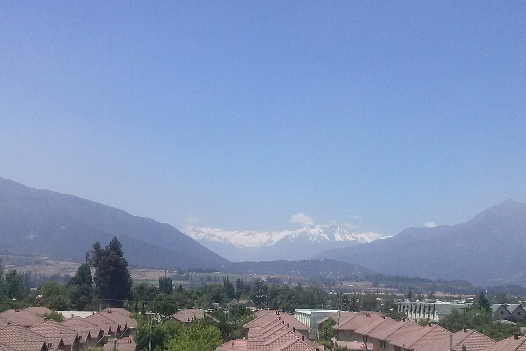 Houses and rooftops in Puente Alto, Santiago, with the Andes in the distance