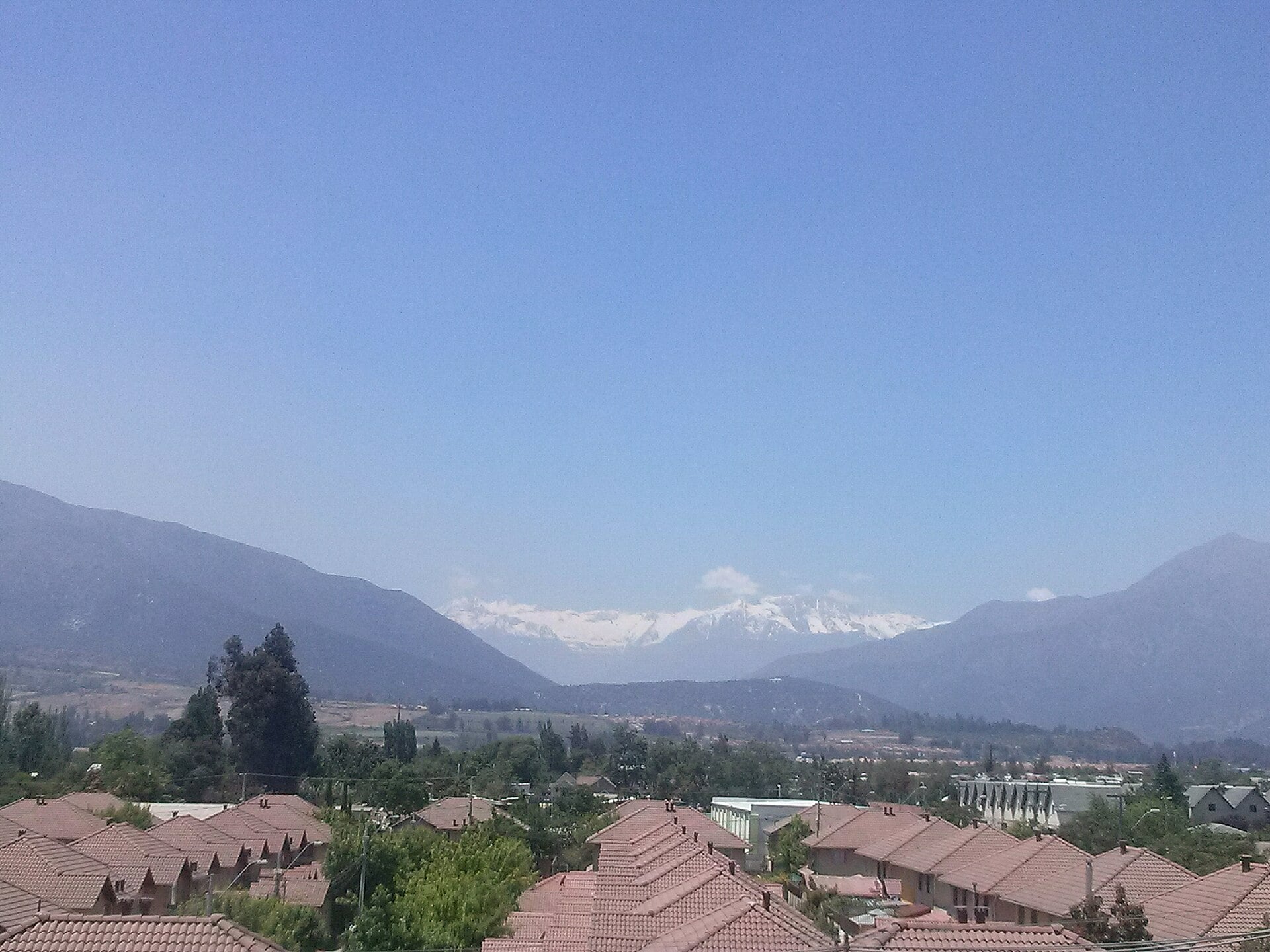 Houses and rooftops in Puente Alto, Santiago, with the Andes in the distance