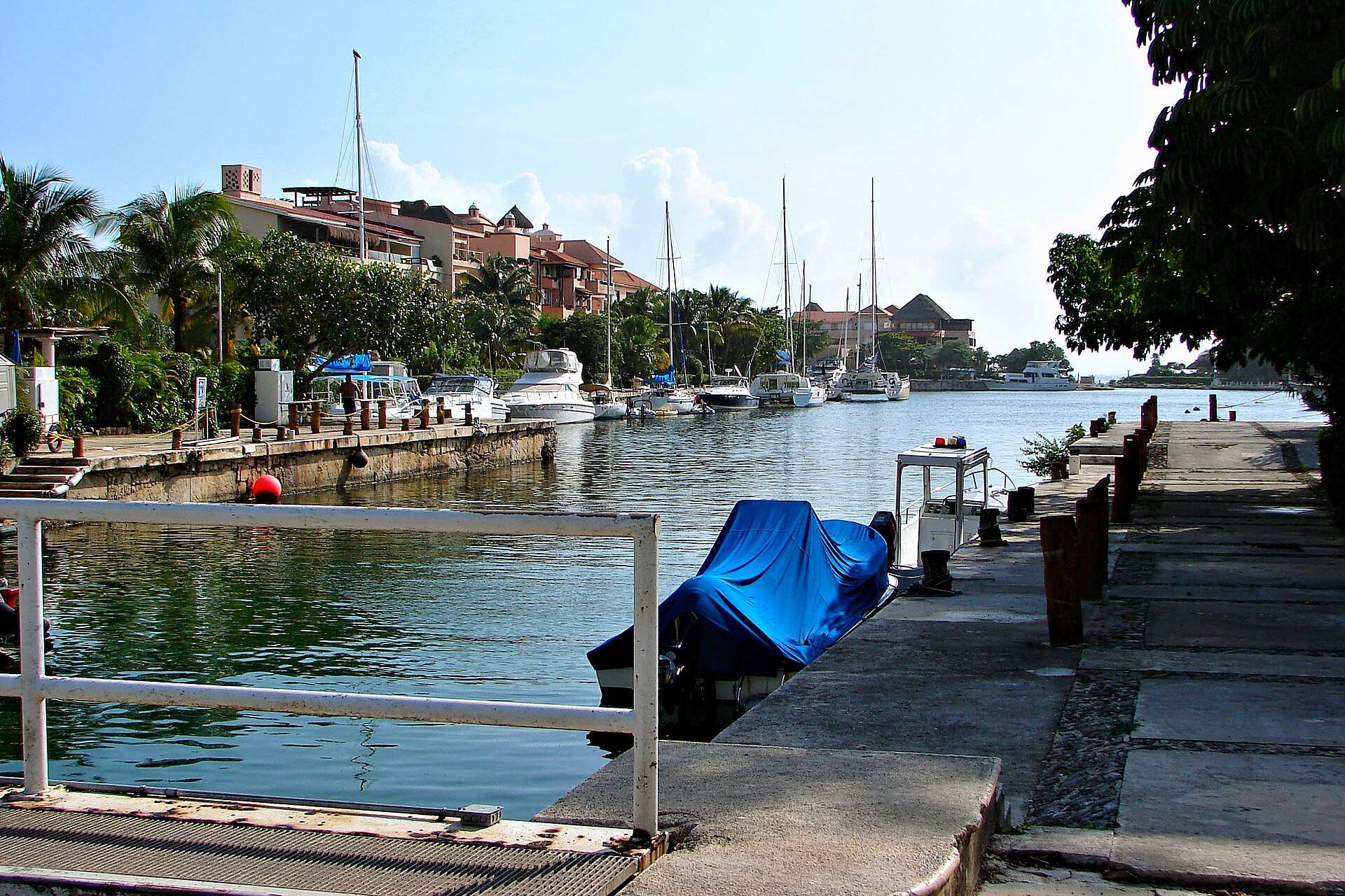 Boats moored in the marina canal at Puerto Aventuras, Quintana Roo, with resort buildings behind