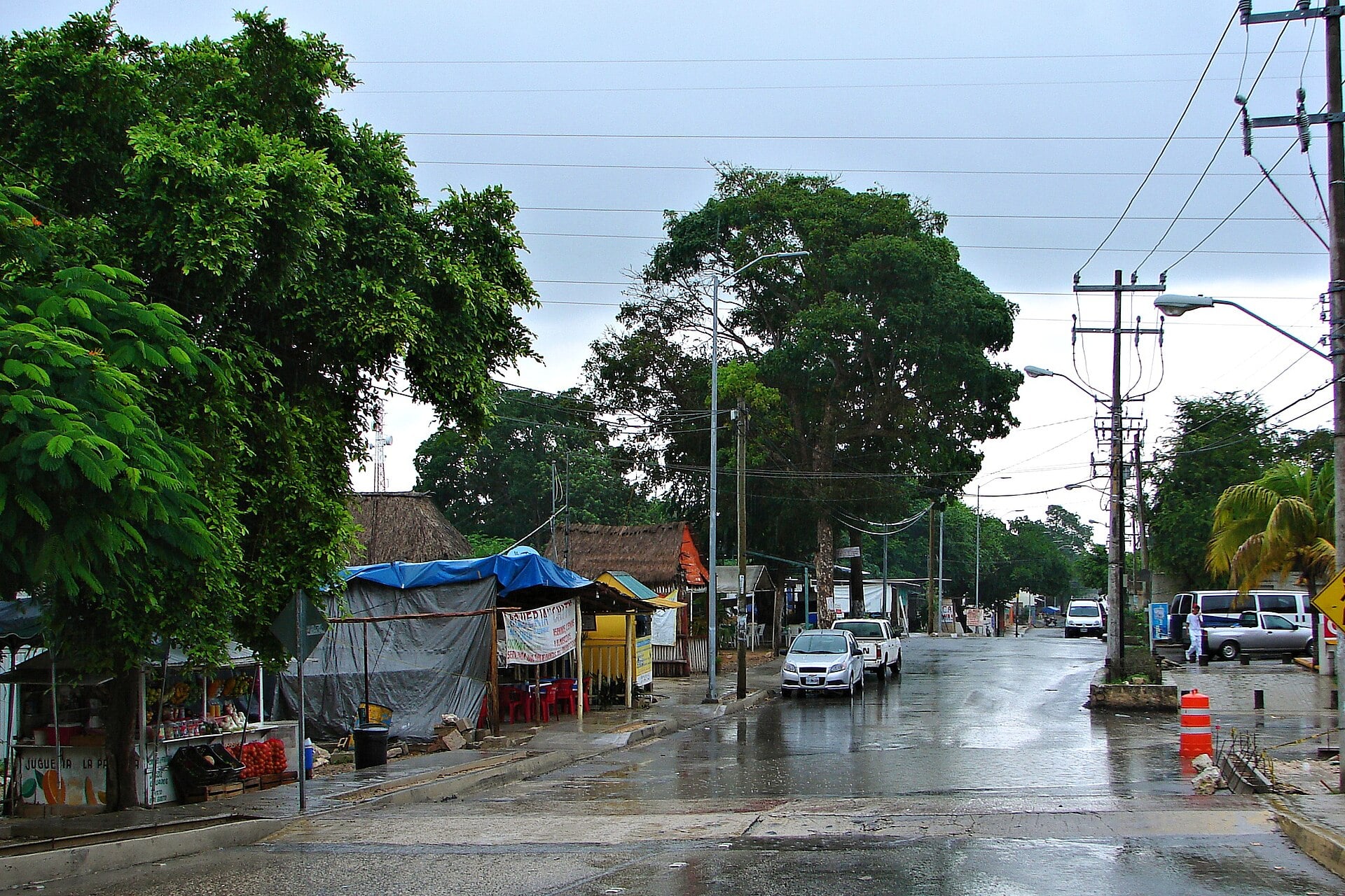 A rainy street with fruit stalls and small shops in the inland village of Puerto Aventuras, Quintana Roo